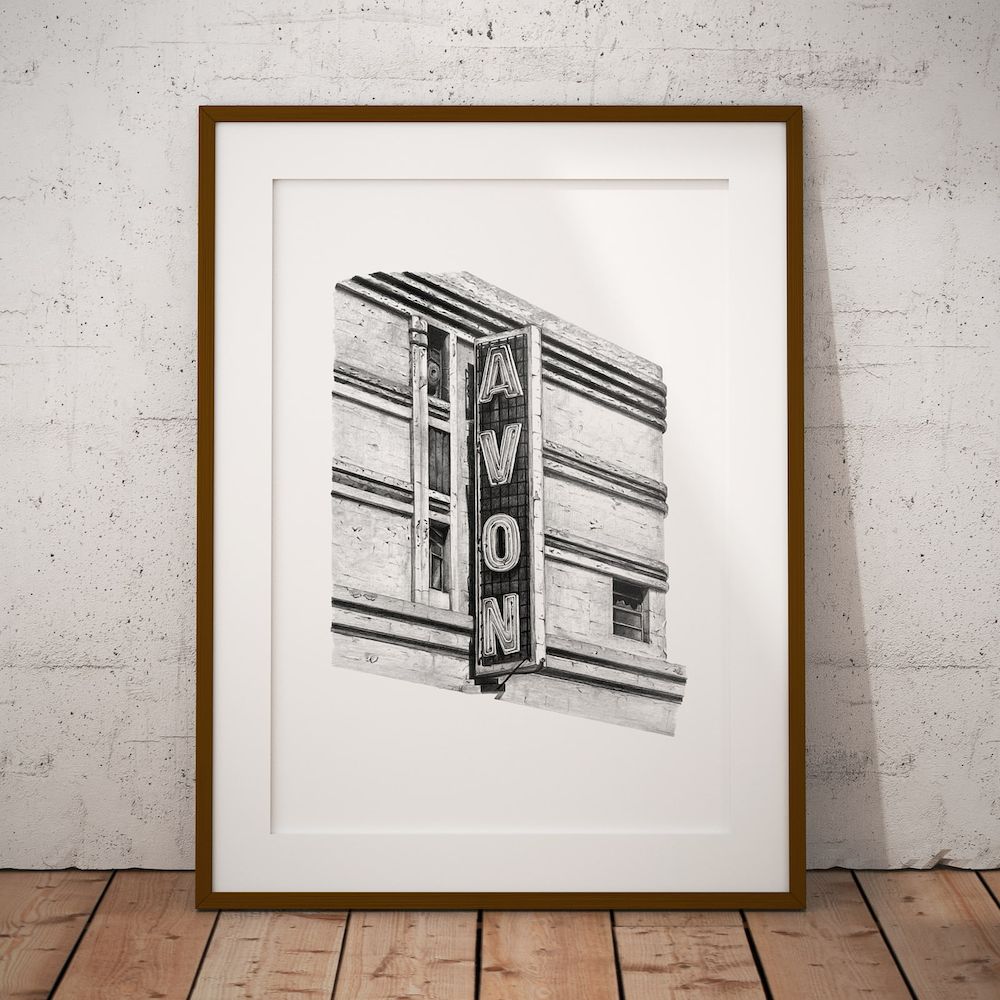 The Avon Theatre print in a slim wooden frame with a white mount, leaning against a concrete wall
